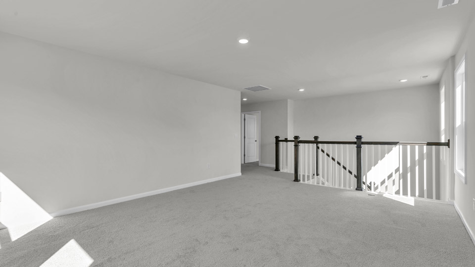 upstairs loft area with large windows and carpeting