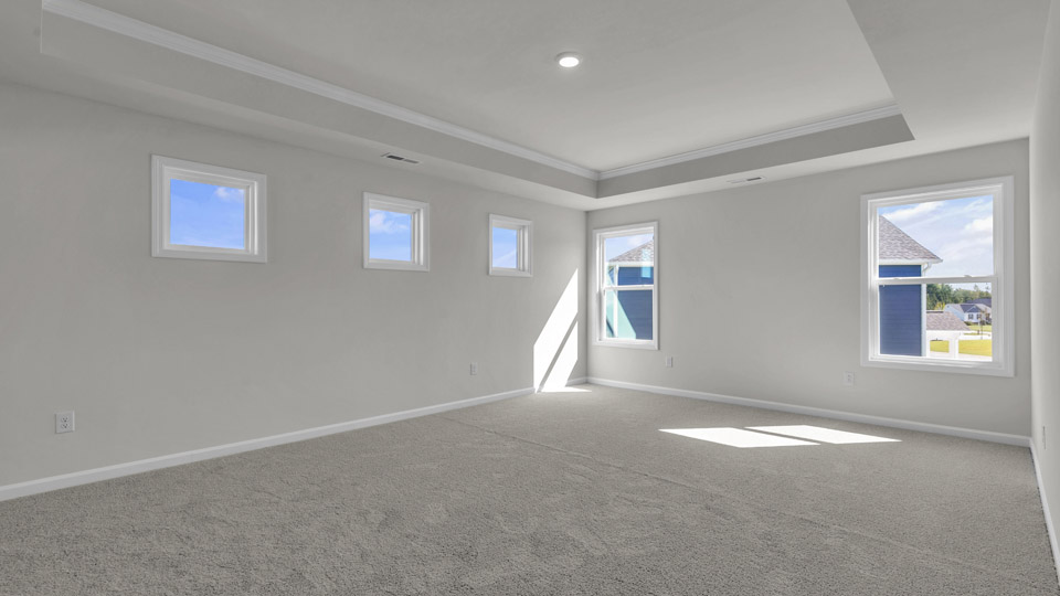 primary bedroom with two windows and carpeting, attached bath