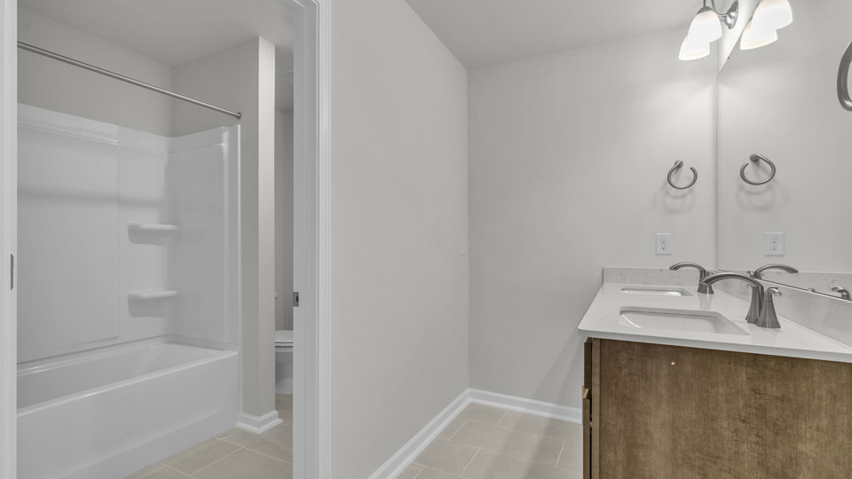 primary bathroom with walk in shower, bathtub, and dual vanity sinks