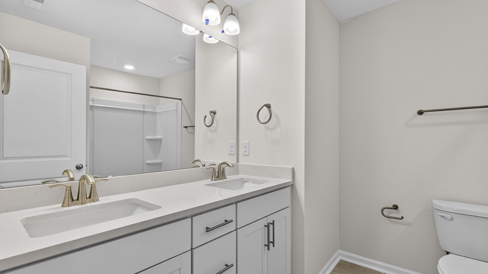 secondary bathroom with shower tub combo and dual vanity sink