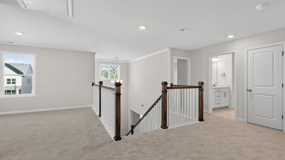 upstairs loft area with large windows and carpeting