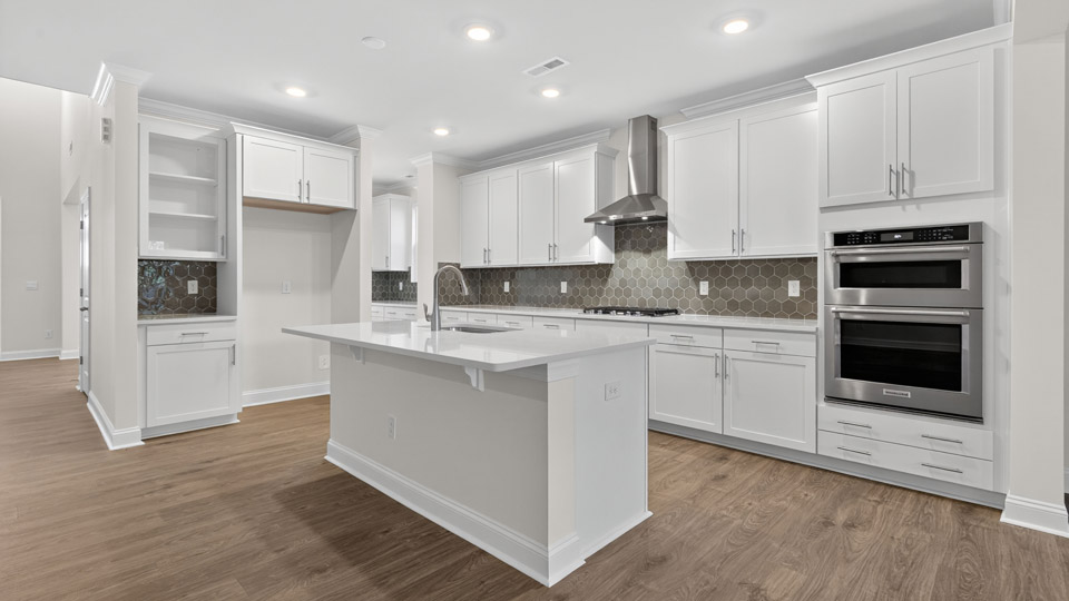 kitchen with quartz counters, kitchen island, pantry, stainless steel appliances