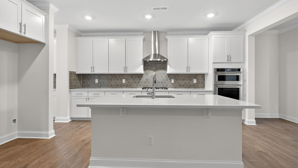 kitchen with quartz counters, kitchen island, pantry, stainless steel appliances