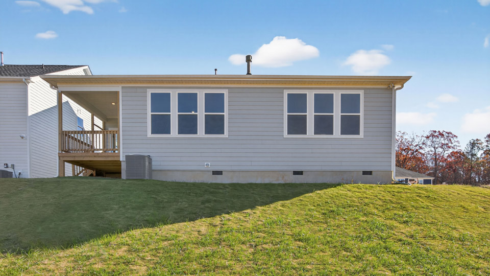 Two story home with blue siding and back patio