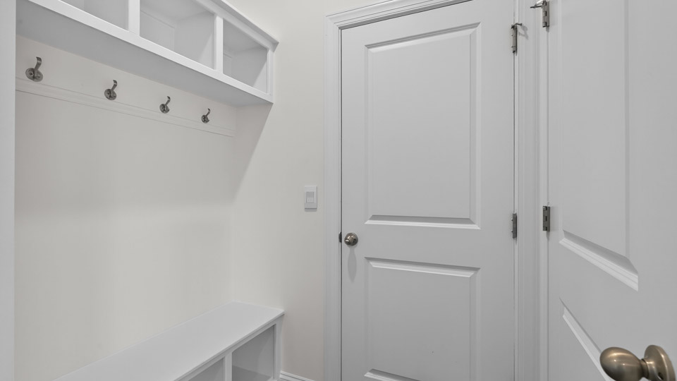 garage door entry into home with mudbench and cubbies