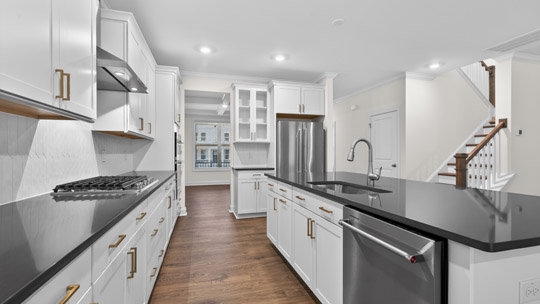 kitchen with island white cabinets quartz countertops and stainless steel appliances