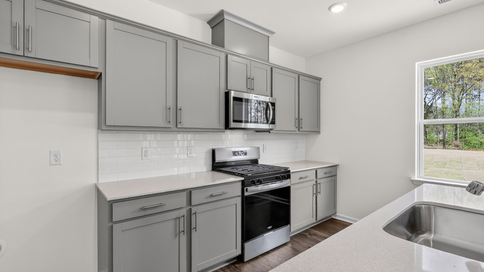 Kitchen with gray cabinets and stainless steel appliances.