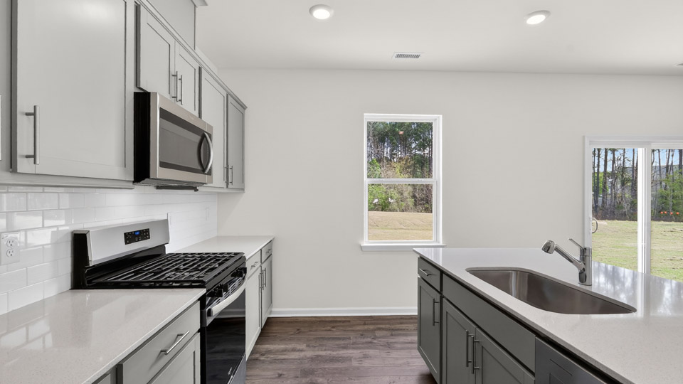 Kitchen with gray cabinets and stainless steel appliances.