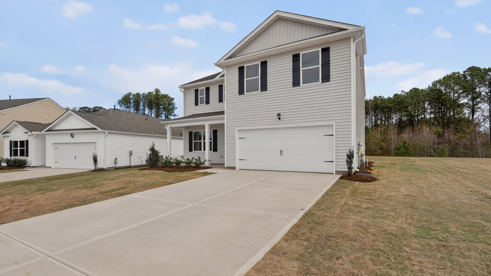 Two story home with white colored siding with a two car garage