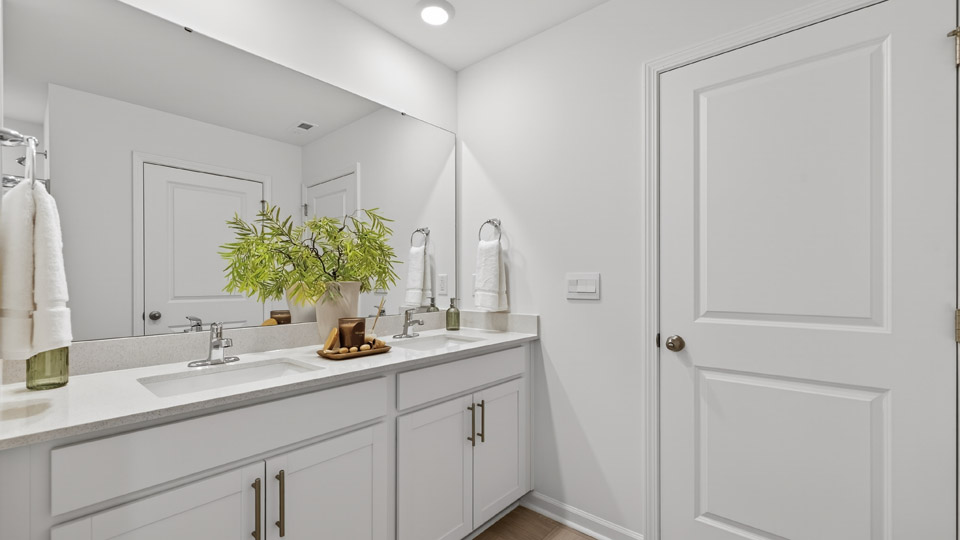primary bathroom with walk in shower and dual vanity sinks