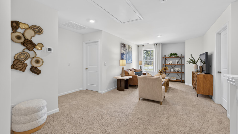 upstairs loft area with large windows and carpeting