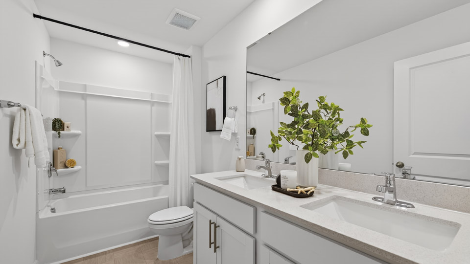 secondary bathroom with shower tub combo and dual vanity sink