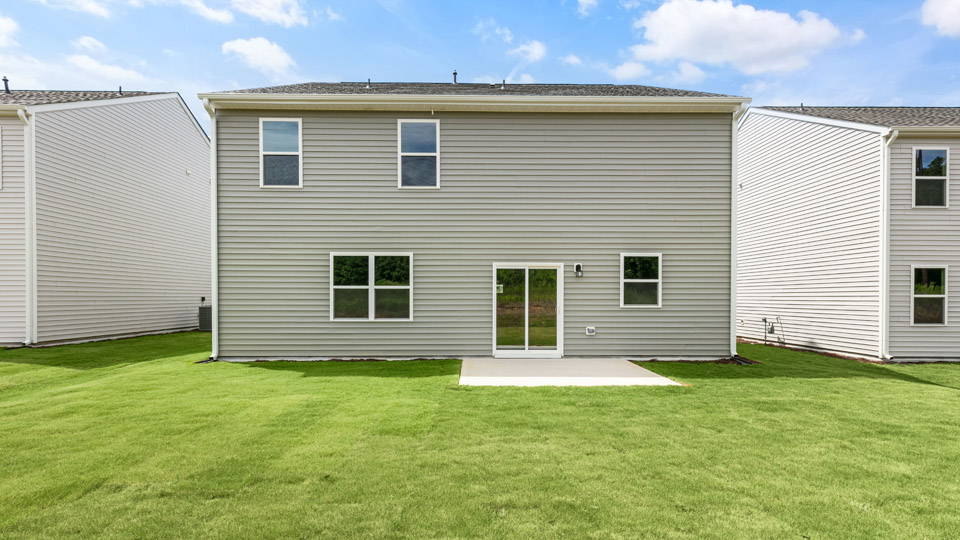 back exterior of Hanover D with concrete patio and open yard