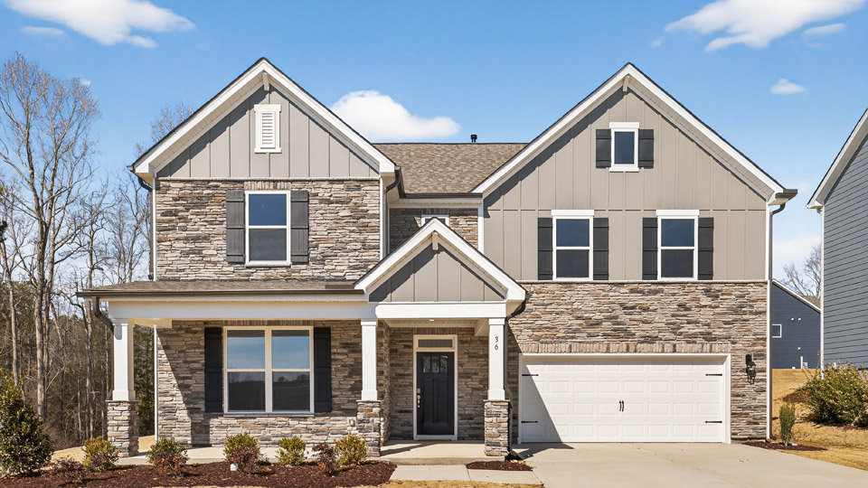 Two story home with brown colored siding with a two car garage