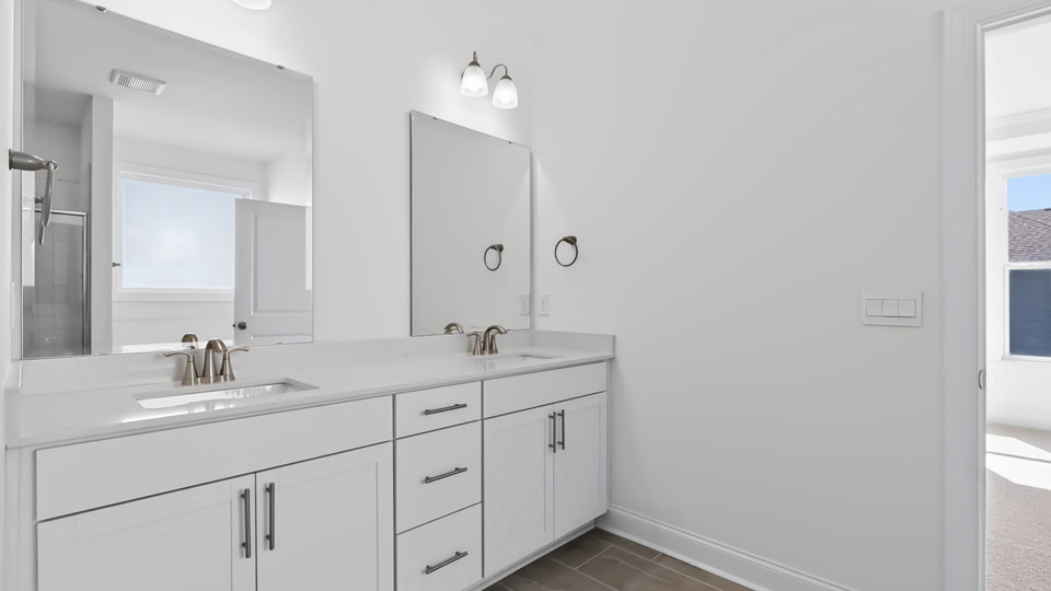 bathroom with white cabinets and quartz countertops