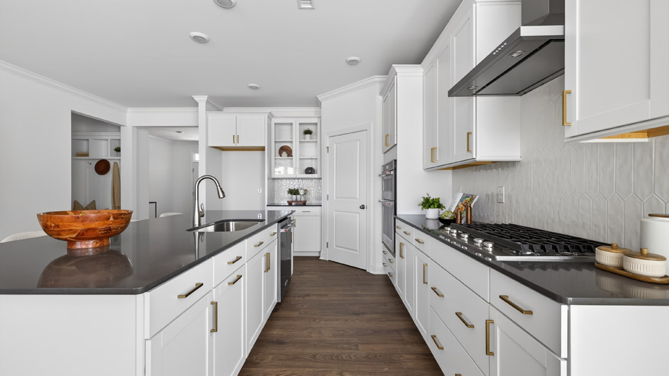 kitchen with quartz counters, kitchen island, pantry, stainless steel appliances