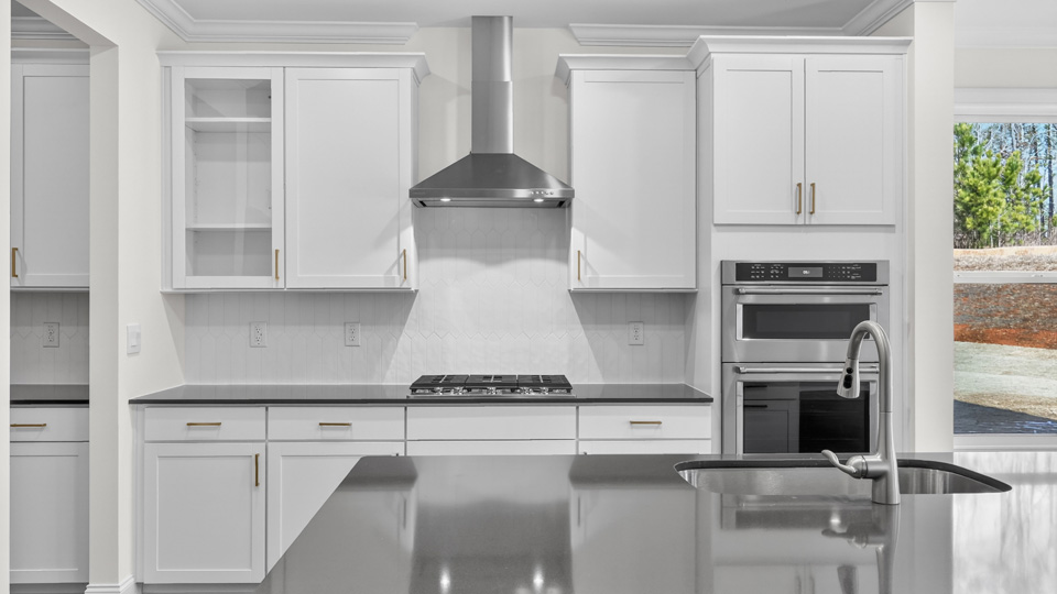 kitchen with quartz counters, kitchen island, pantry, stainless steel appliances