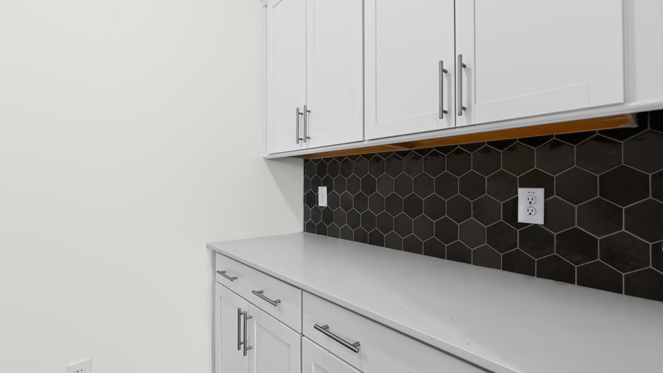 butlers pantry with quartz countertops and tile backsplash