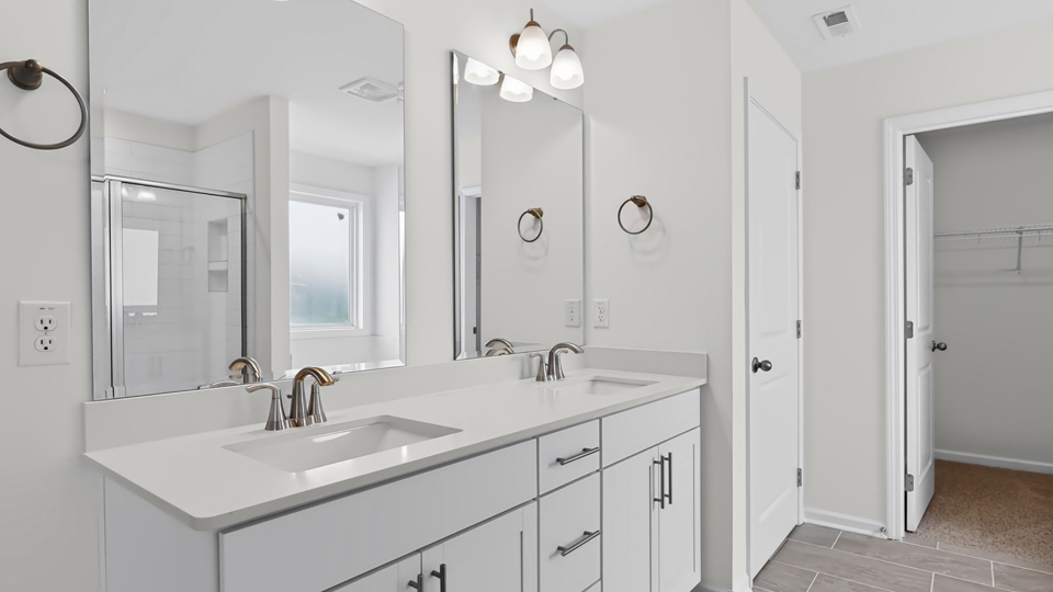 bathroom with dual vanity and white cabinets