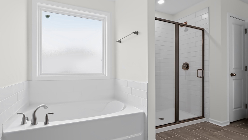 primary bathroomo with separate tub and walkin shower