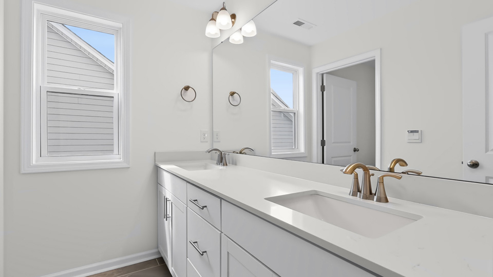 bathroom with white cabinets and quartz countertops