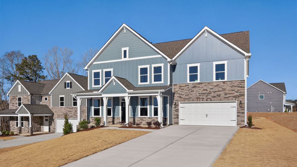 Two story home with gray siding and a two-car garage.