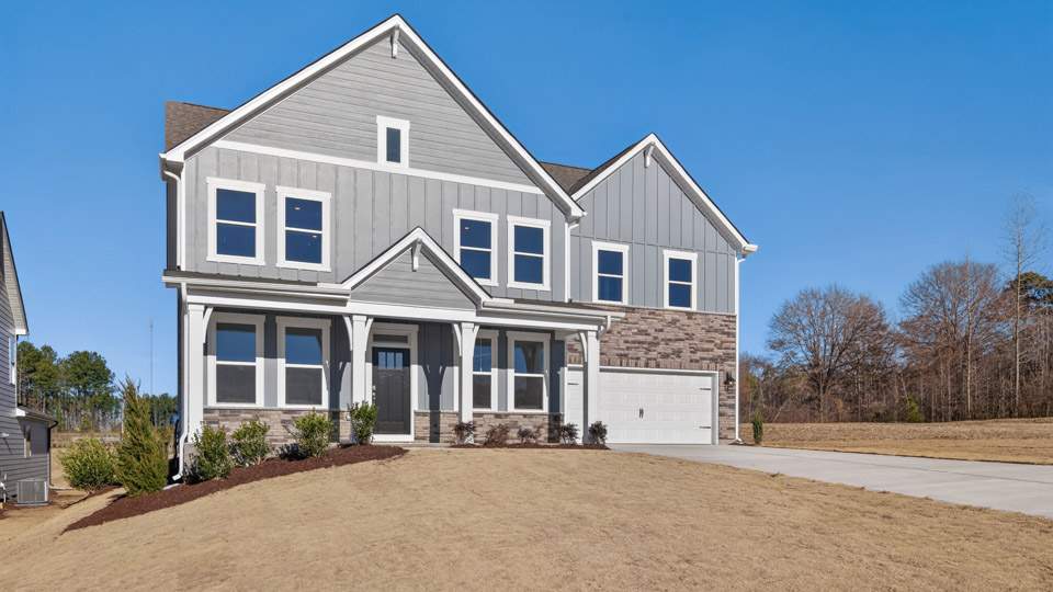 Two story home with gray siding and a two-car garage.
