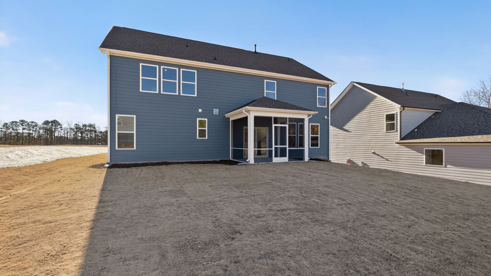 Two story home with gray siding and a covered back patio.
