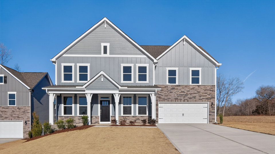 Two story home with gray siding and a two-car garage.