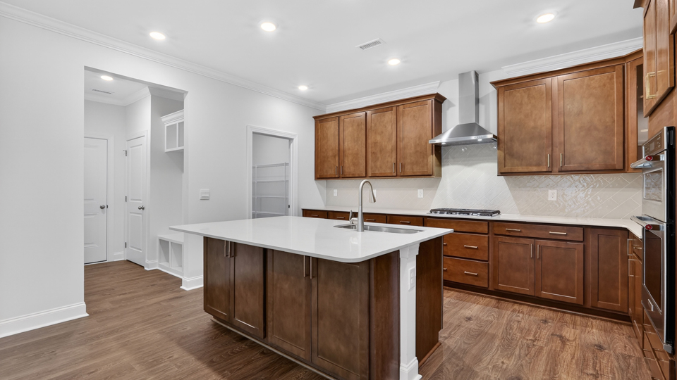kitchen with brown cabinets quartz countertops and spacious island