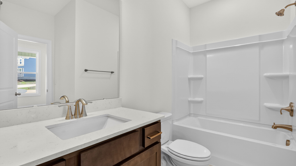 bathroom with brown cabinets and tub shower combo