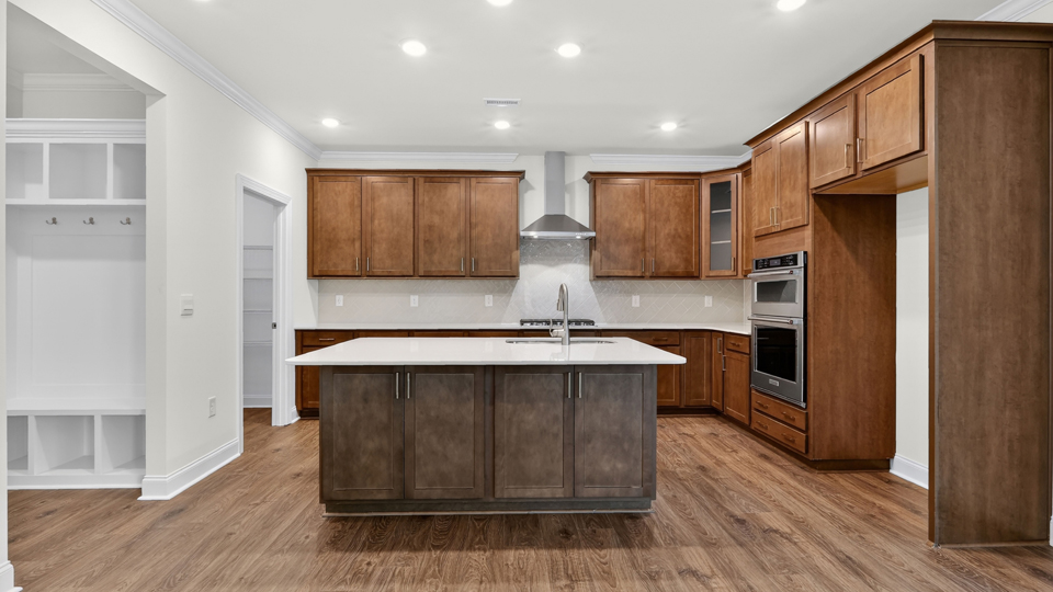 kitchen with brown cabinets spacious island and quartz countertops