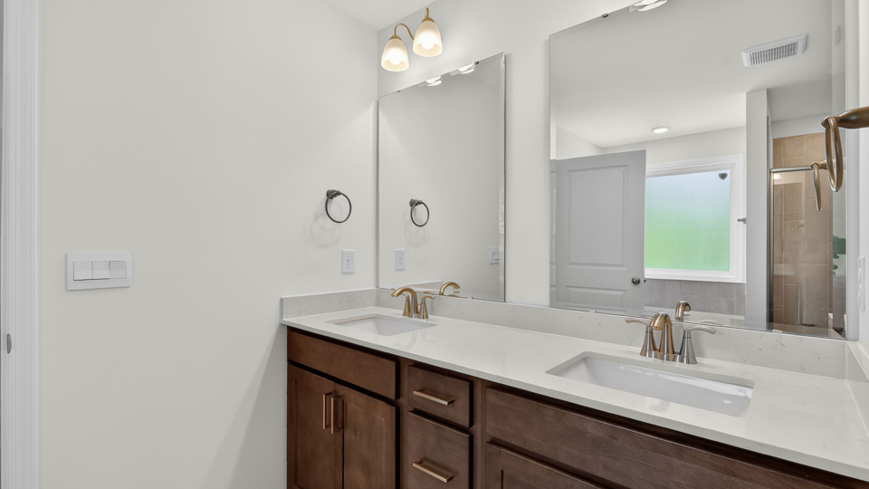 bathroom with dual vanity and quartz countertops
