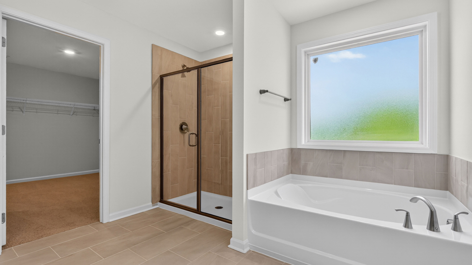 primary bathroom with separate tub and walkin shower