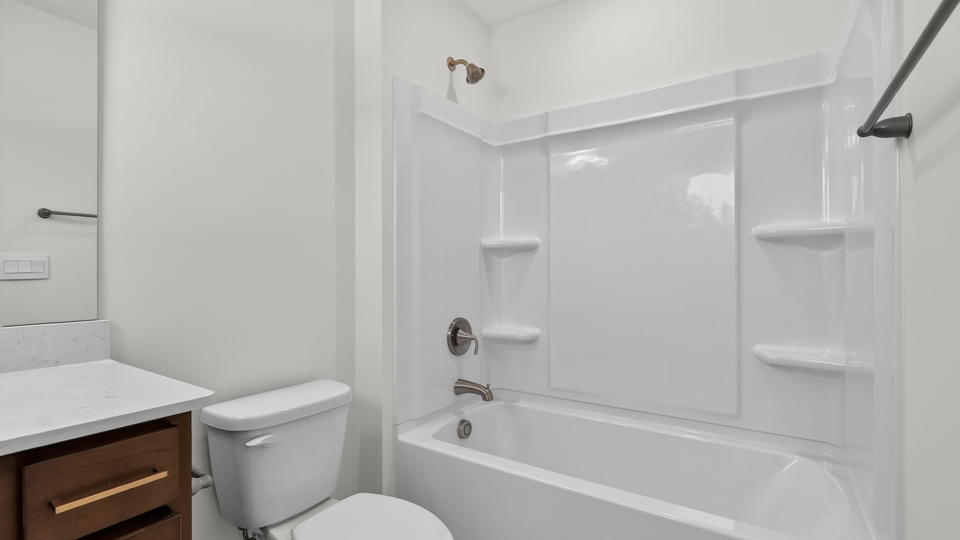 bathroom with brown cabinets and tub shower combo