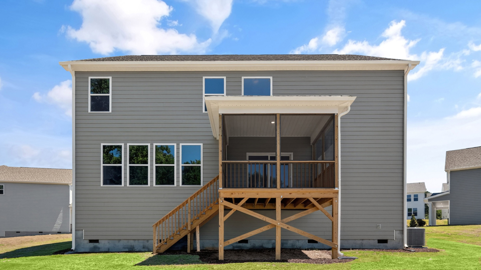 back of home with covered and screened deck