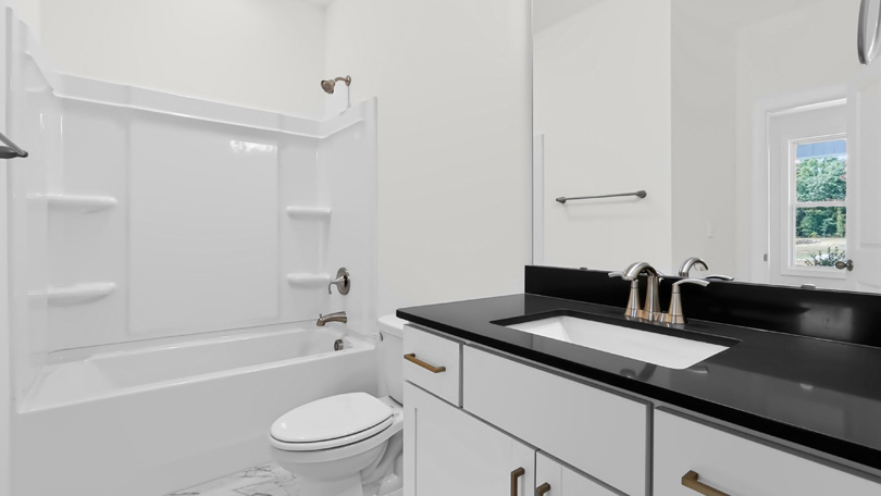 bathroom with white cabinets and quartz countertops