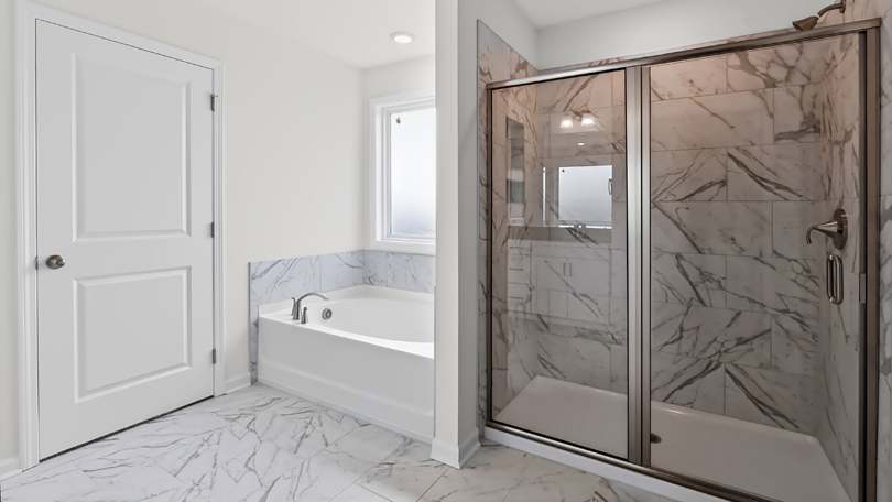 primary bathroom with separate tub and walkin glass door shower