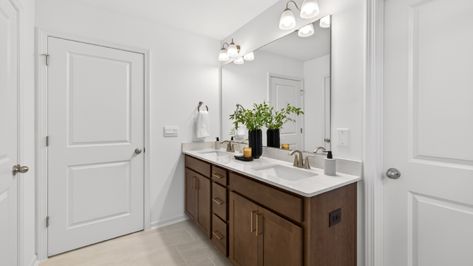 primary bathroom with walk in shower and dual vanity sinks