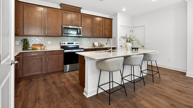 kitchen with quartz counters, kitchen island, pantry, stainless steel appliances