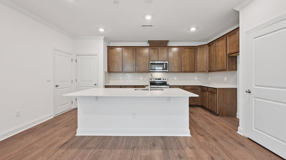 kitchen with brown cabinets quartz countertops and kitchen island