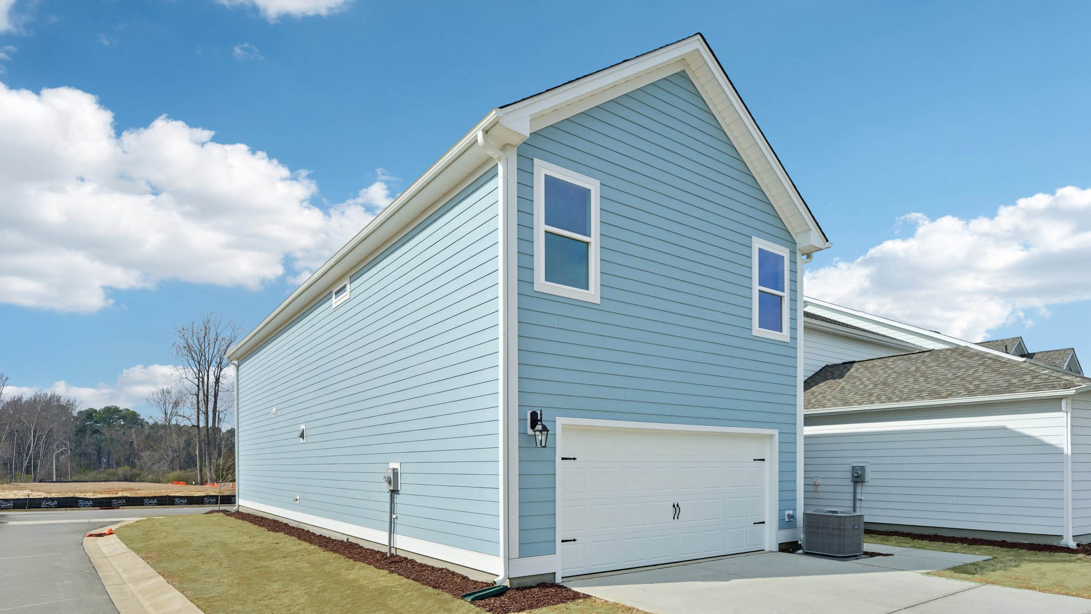 back of home with two car garage on corner lot