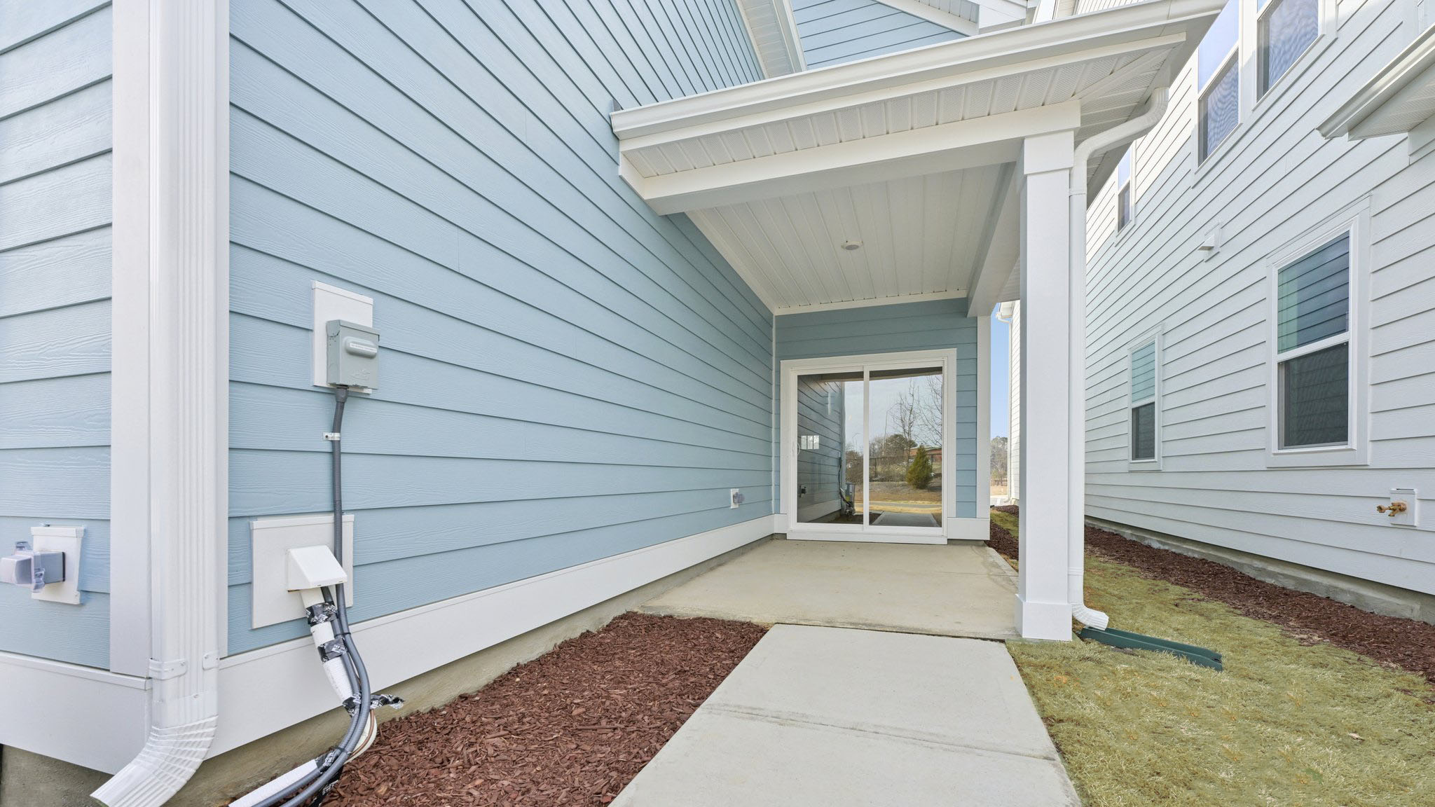 covered back patio with sliding glass doors