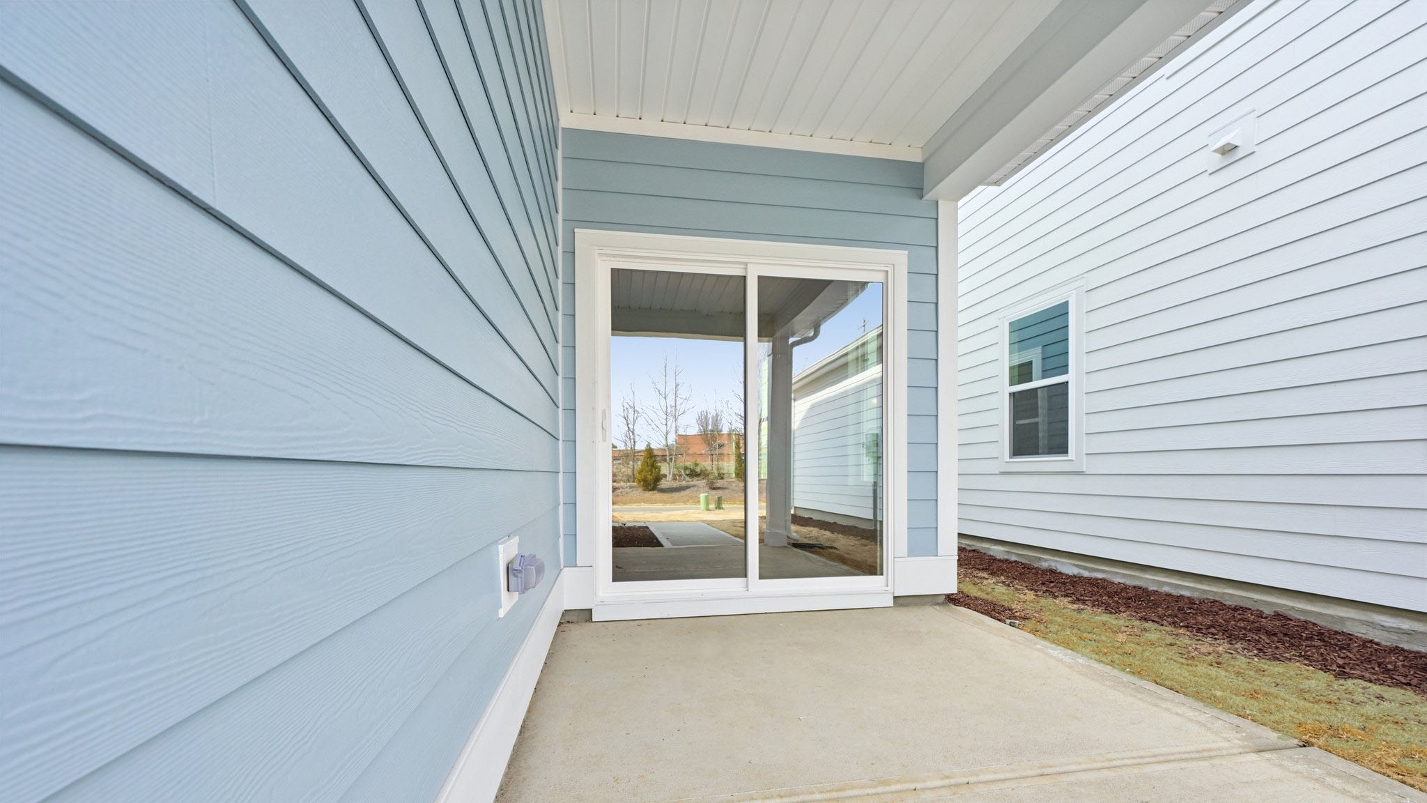 covered back patio with sliding glass doors