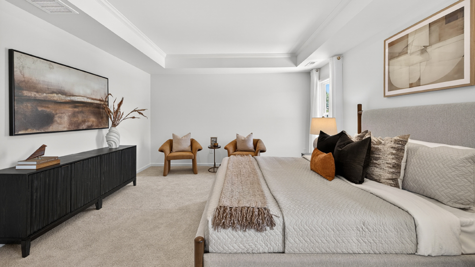 primary bedroom with two windows and carpeting, attached bath