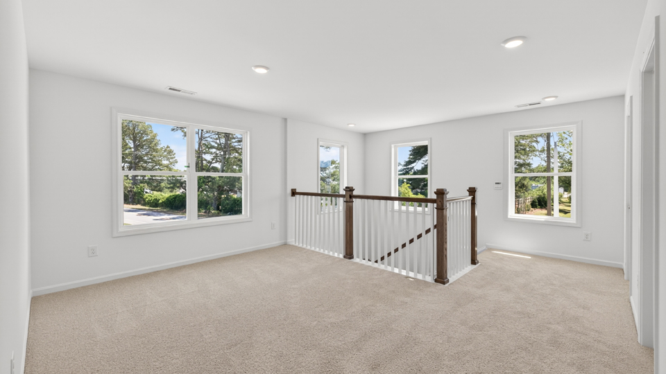 upstairs loft area with large windows and carpeting