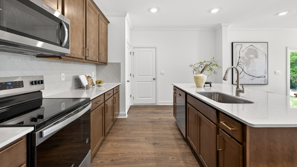 kitchen with quartz counters, kitchen island, pantry, stainless steel appliances