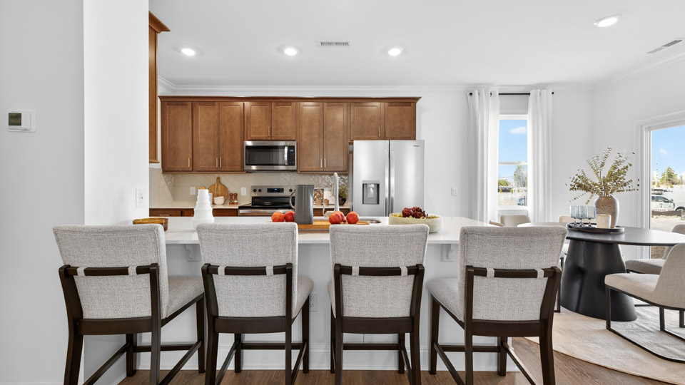 kitchen with quartz counters, kitchen peninsula, pantry, stainless steel appliances