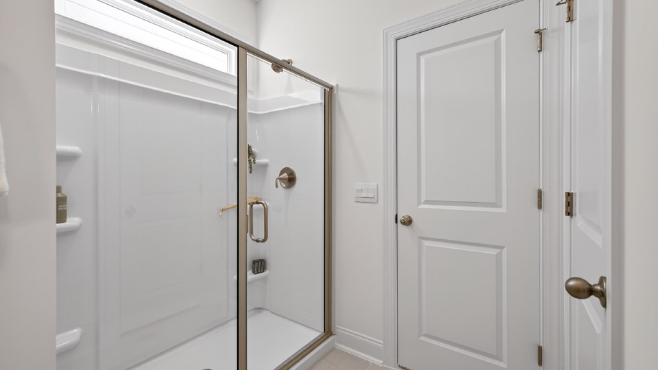 secondary bathroom with walk in shower and single vanity sink