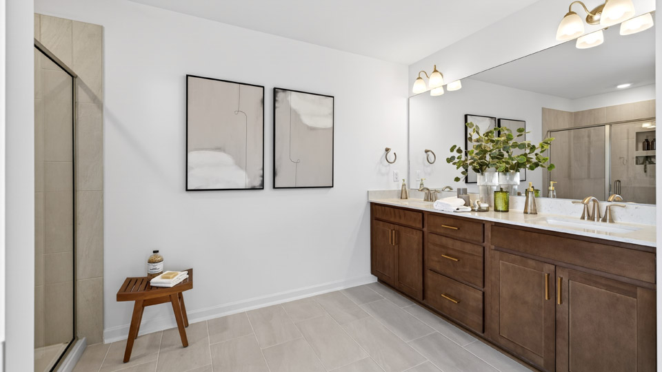 primary bathroom with walk in shower, bathtub, and dual vanity sinks